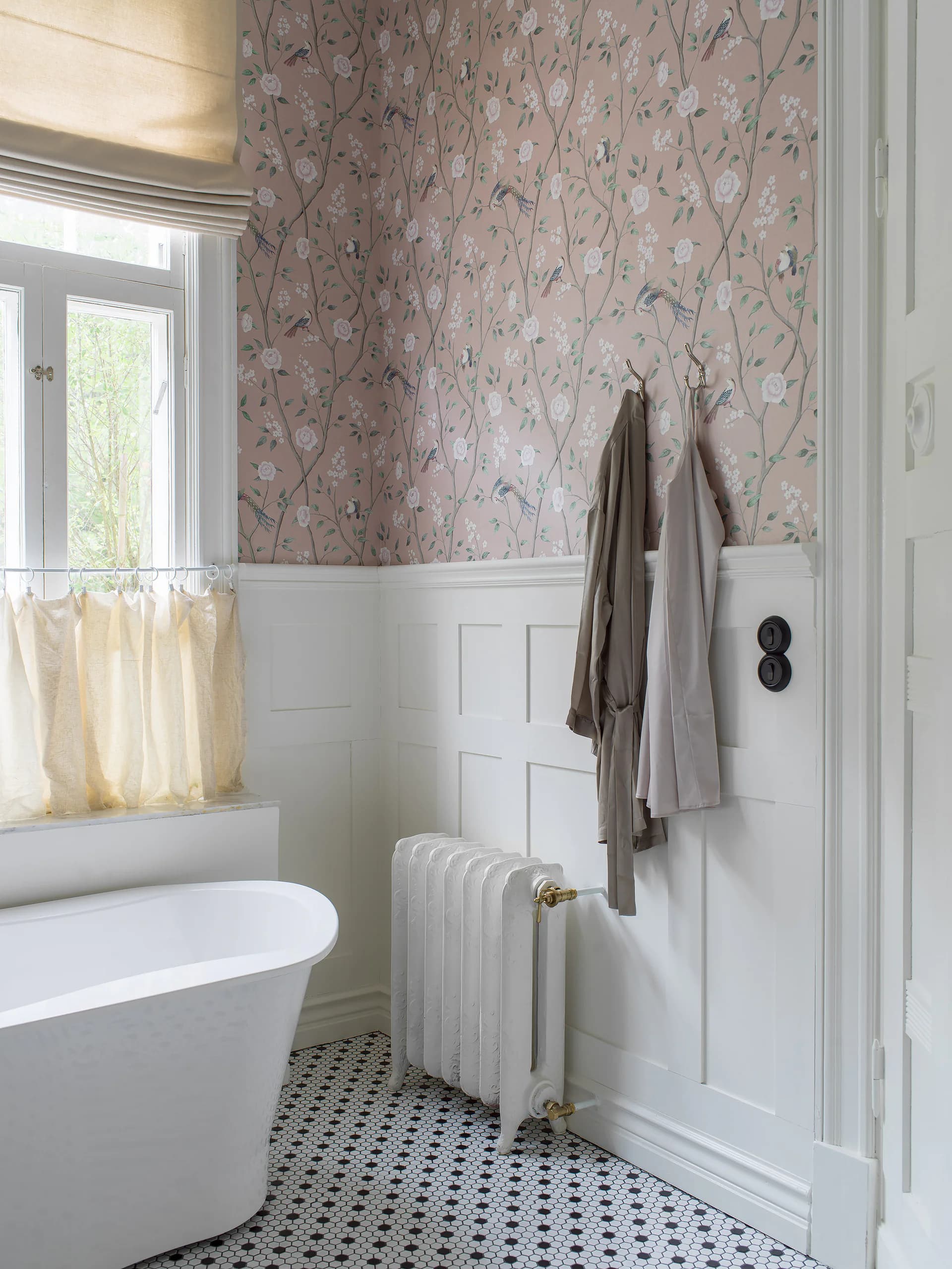Badkamer met bloesembehang boven witte lambrisering