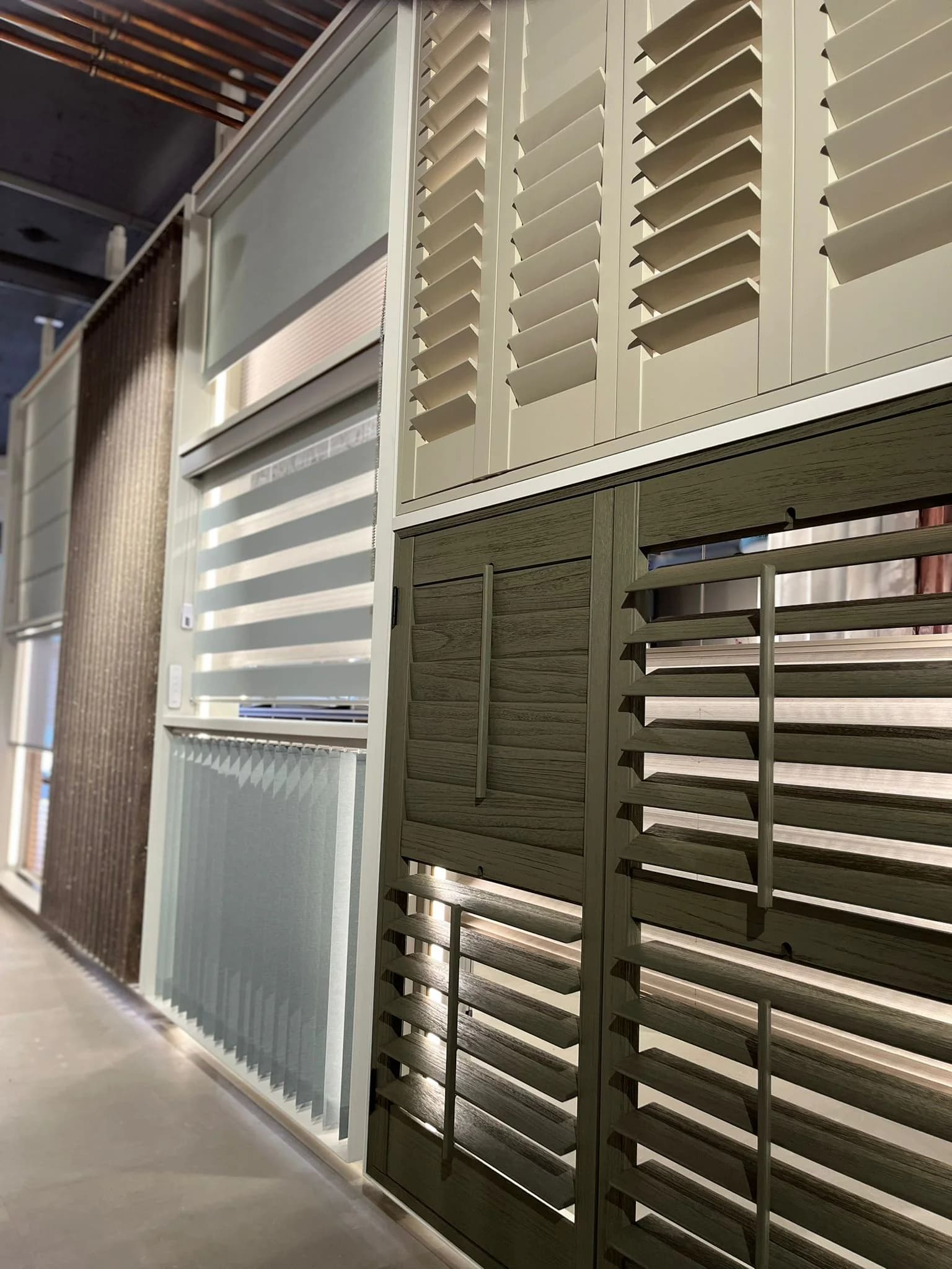 Wand met shutters en jaloezieën in verschillende kleuren en houtsoorten