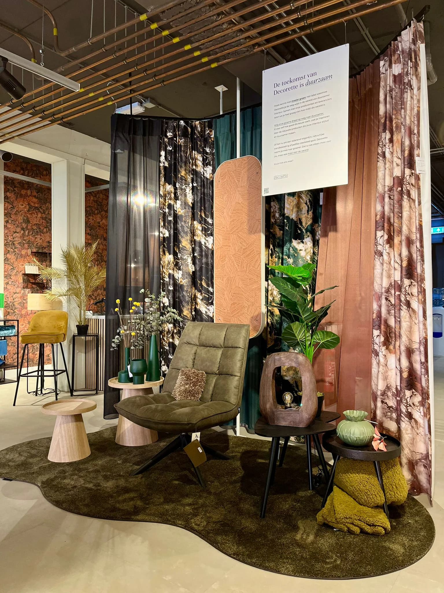 Showroom met een compleet ingerichte zithoek, gordijnen en planten