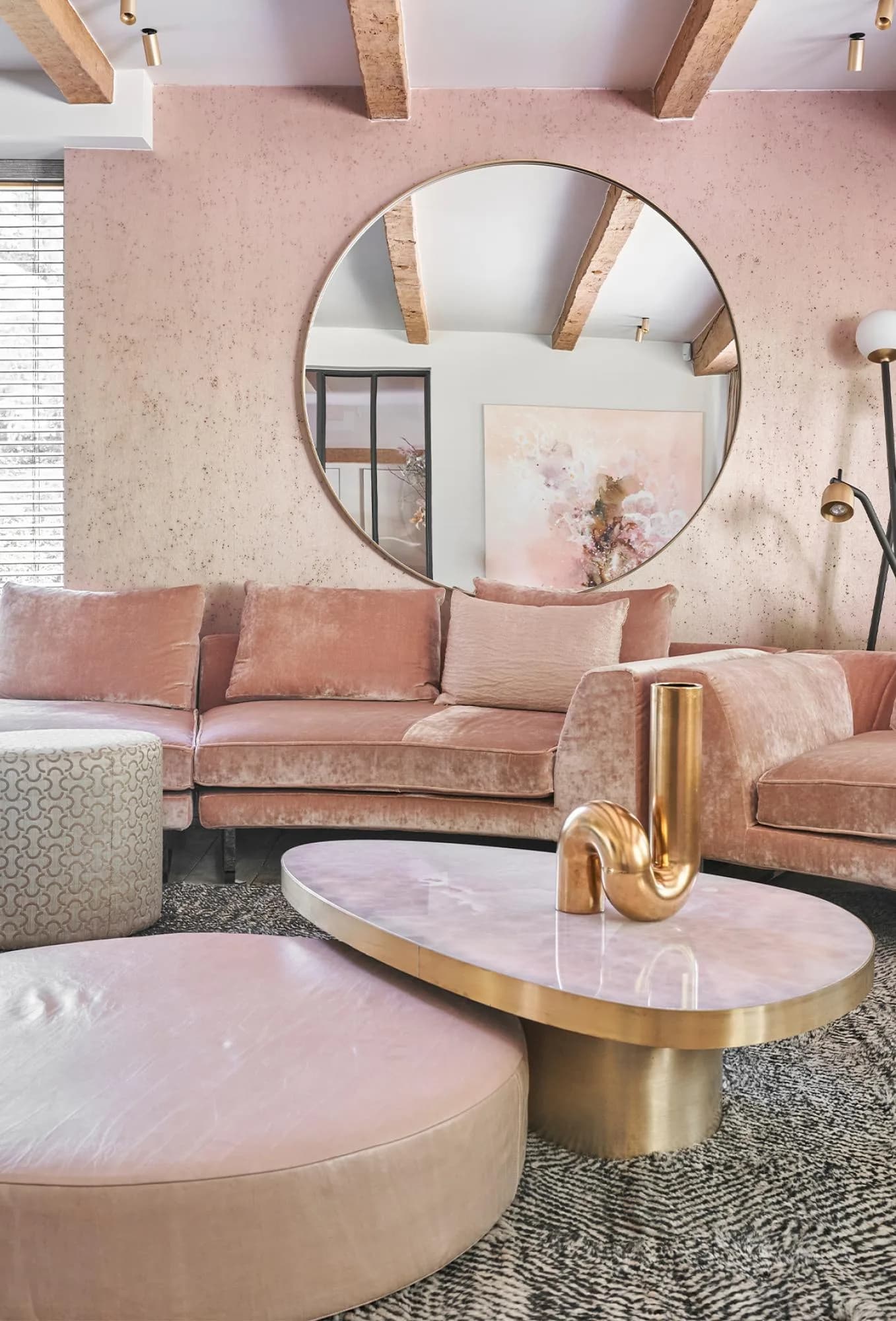Roze bank en ronde spiegel voor een wand met zacht roze Arte-behang