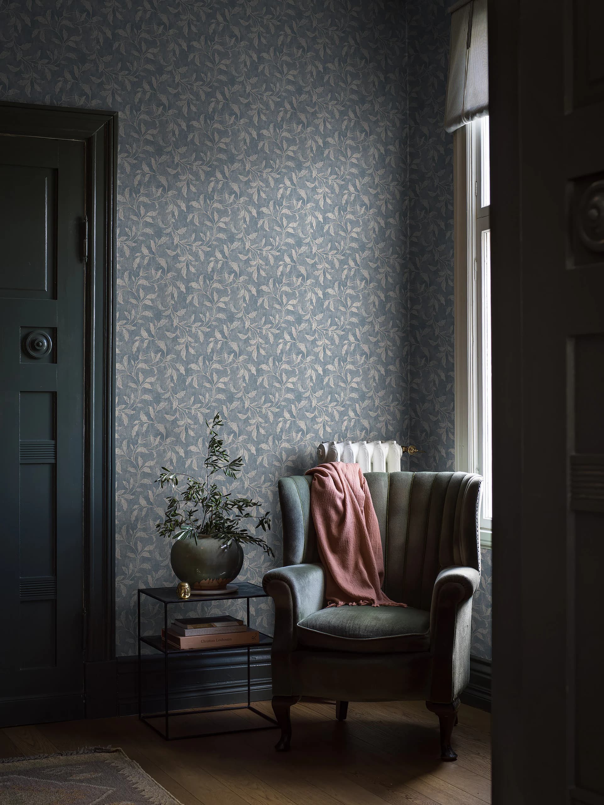 Leeshoek met fauteuil voor behang met bladpatroon