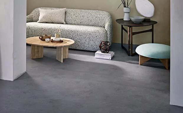 Woonkamer met een naadloze grijze vloer in betonlook
