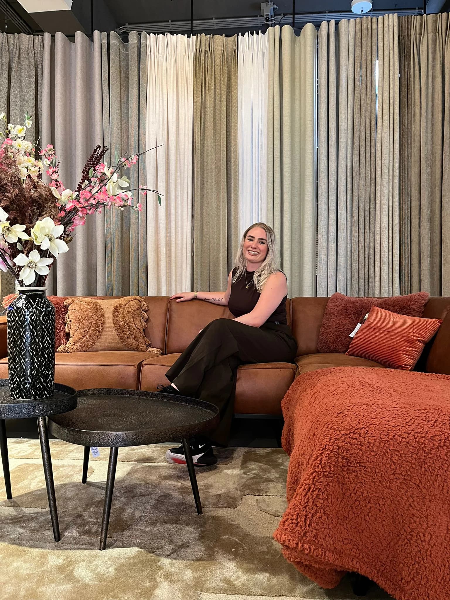 Wand met gordijnstoffen achter een hoekbank in de showroom