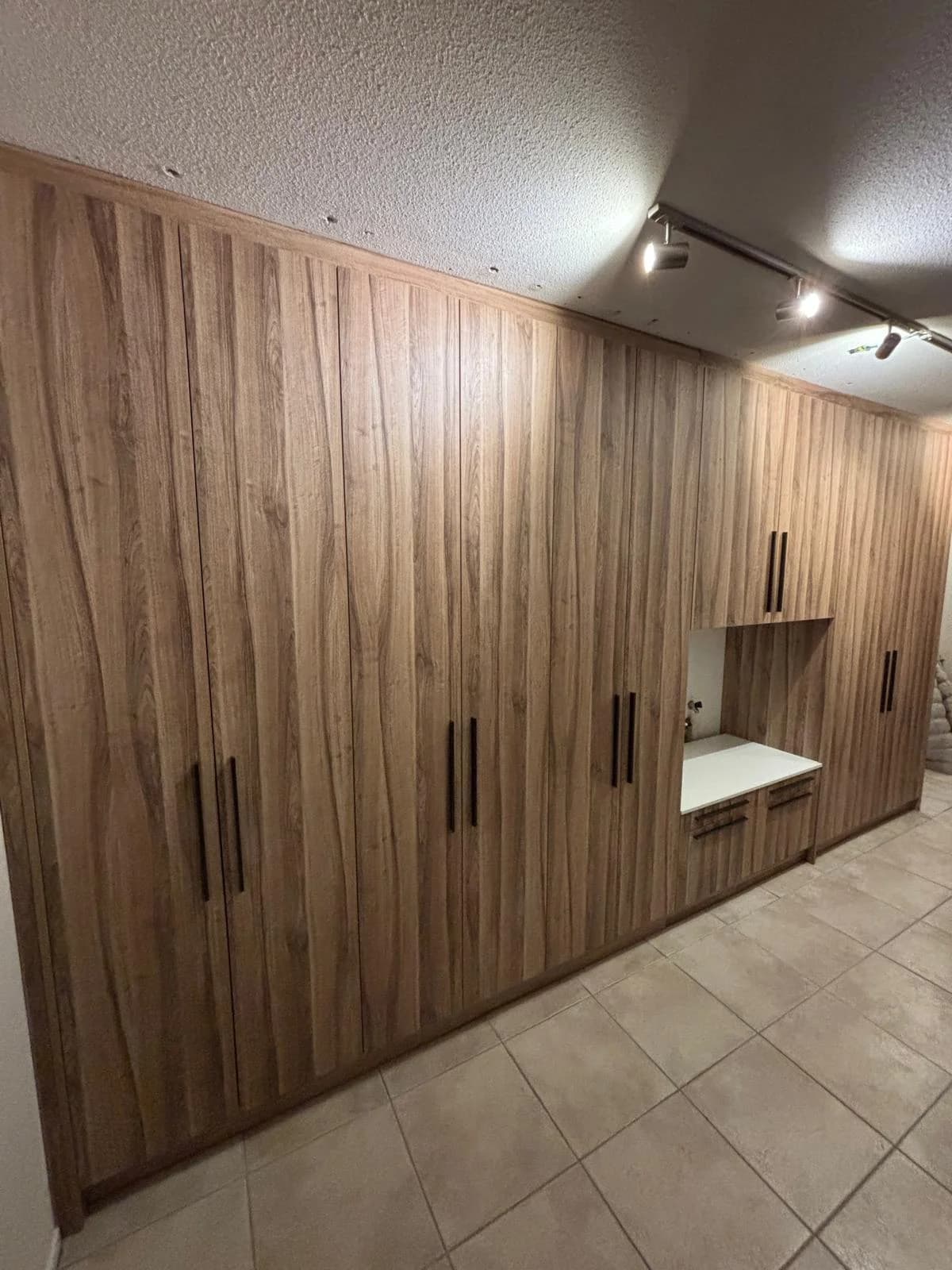 Kastenwand op maat in houtlook met een open nis en laden