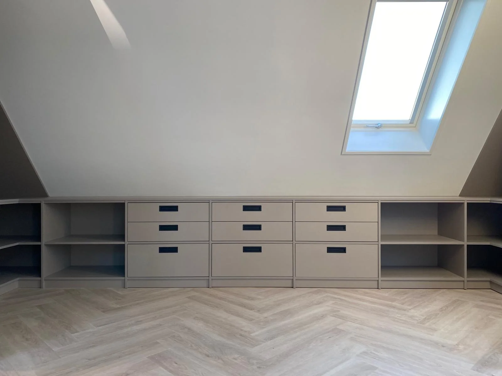 Kastenwand met lades en open vakken langs het knieschot