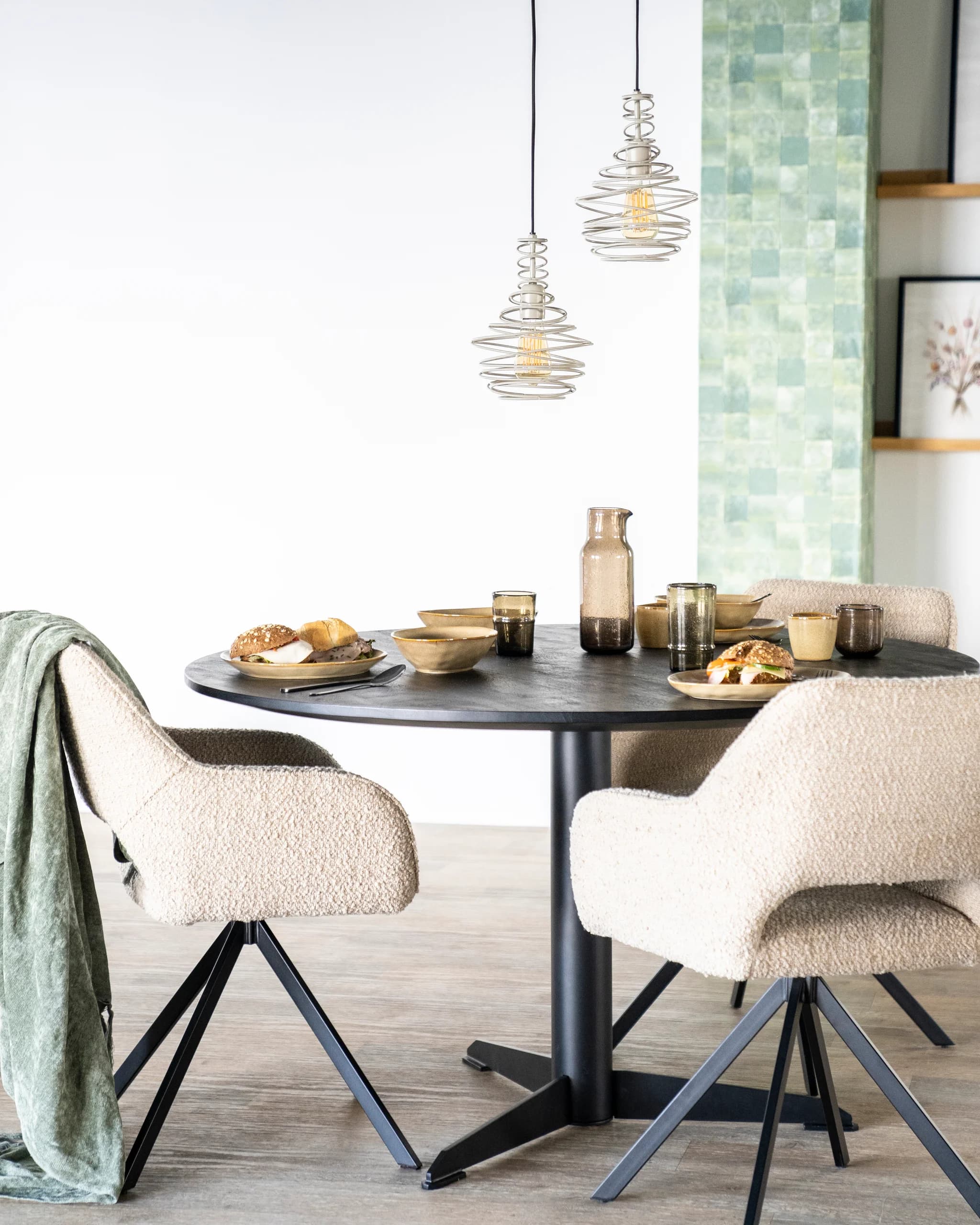 Ronde eettafel met bouclé stoelen en glazen hanglampen