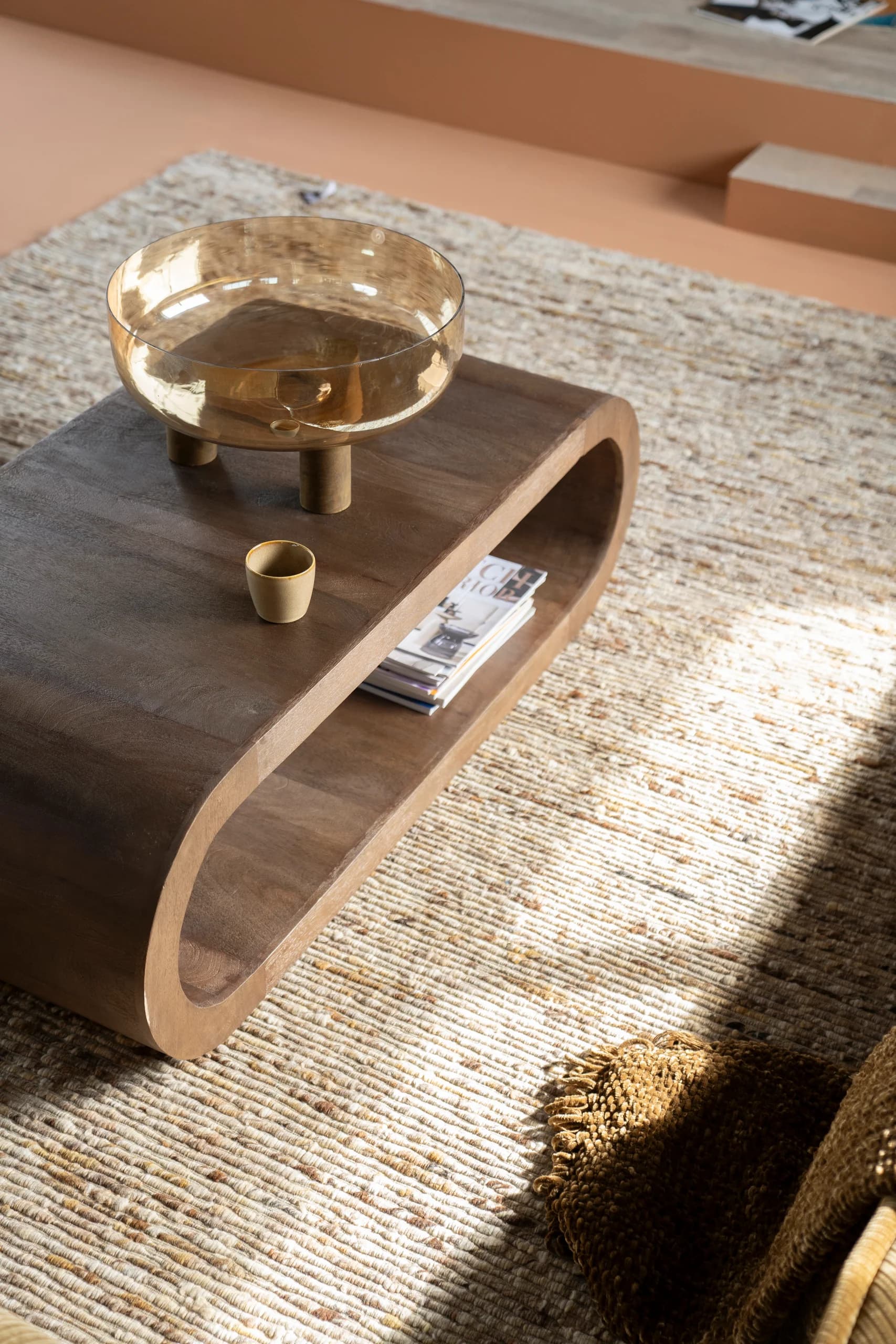 Ovale houten salontafel op een jute vloerkleed