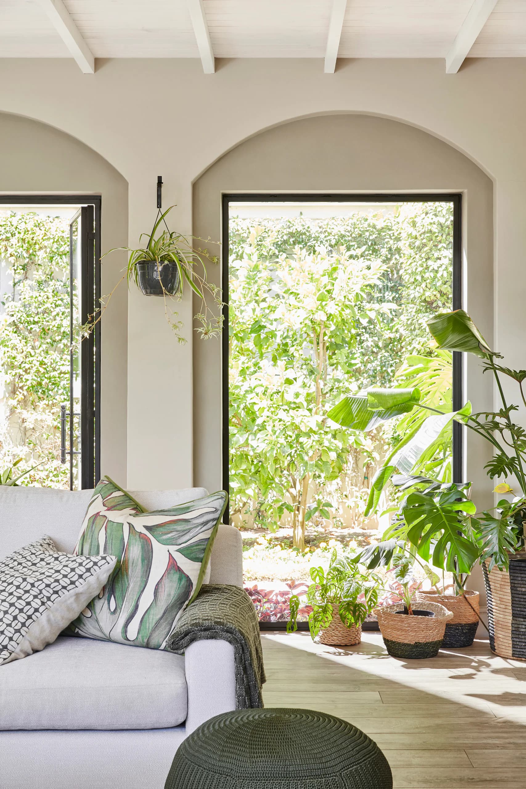 Lichte woonkamer met boogramen naar de tuin (Flint, Portland Stone)